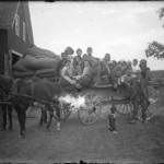 Vintage horse-drawn wagon with travelers and luggage.