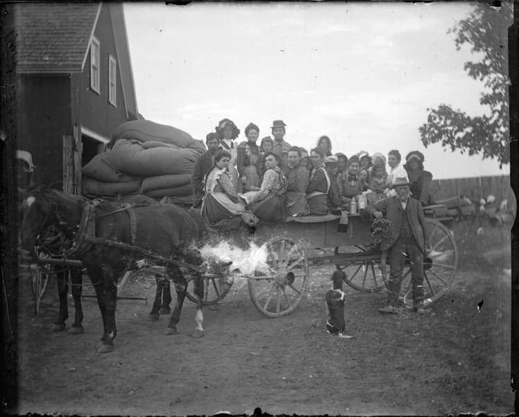 Vintage horse-drawn wagon with travelers and luggage.