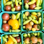 Vibrant heirloom tomatoes and fresh green beans displayed in eco-friendly baskets for garden-fresh produce.
