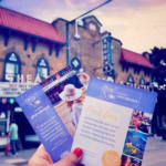 Hand holding food tour flyers outside a historic theatre in Prince Edward County.