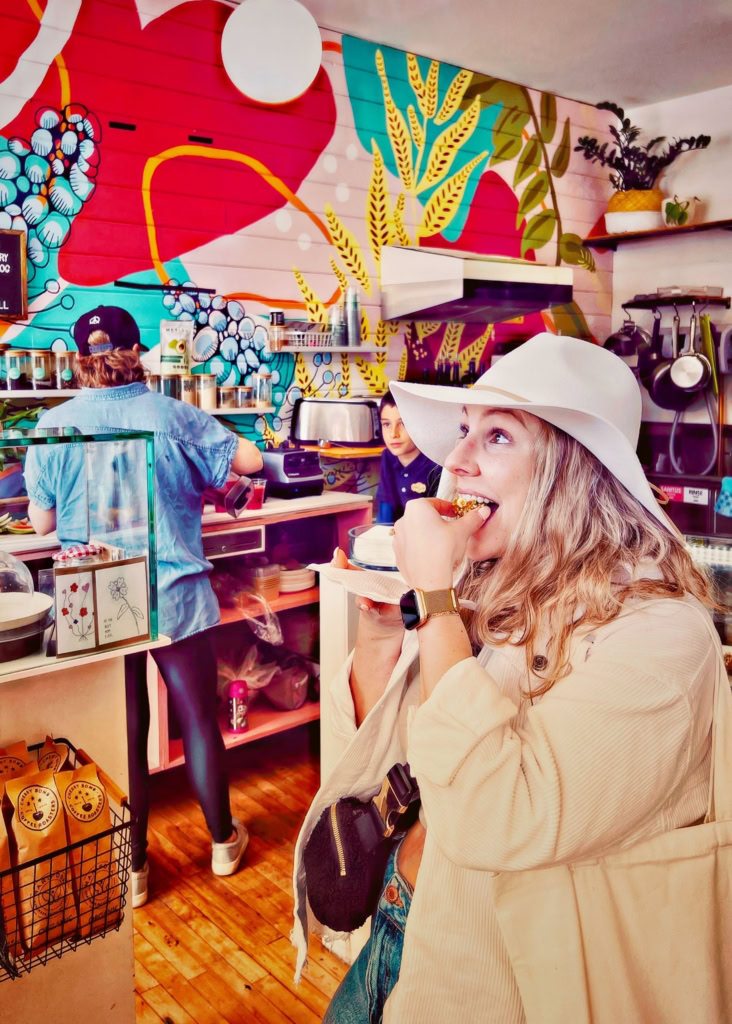 Bright, lively café interior featuring colorful wall art, casual ambiance, and guests savoring delicious treats.
