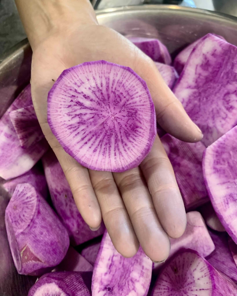 Fresh watermelon radish slices with vibrant purple and white color, perfect for gourmet presentations.