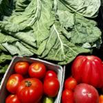 Vivid image of ripe tomatoes and leafy greens perfect for gourmet cooking and farm-to-table dishes.