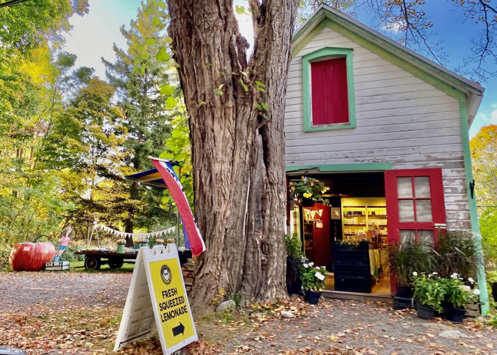 Bright red accents on a quaint white wooden building with an inviting storefront and fresh lemonade sign.