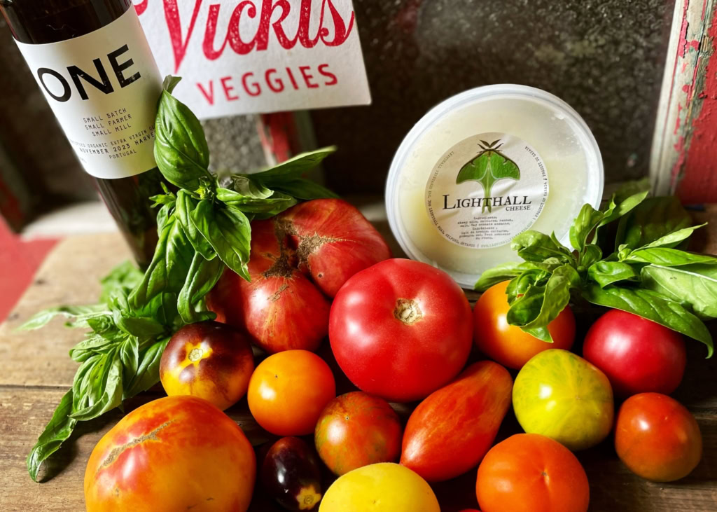 Vibrant heirloom tomatoes, fresh basil, cheese, and wine for gourmet dining.