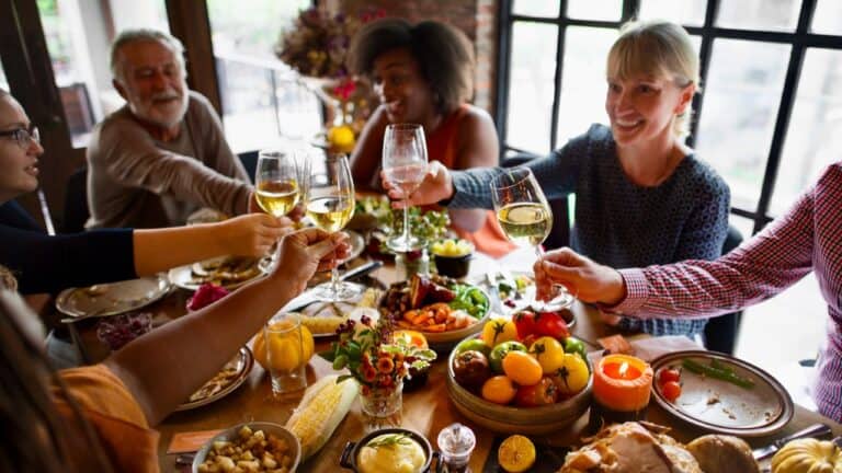 Guests raising glasses at a festive fall-themed dinner party.