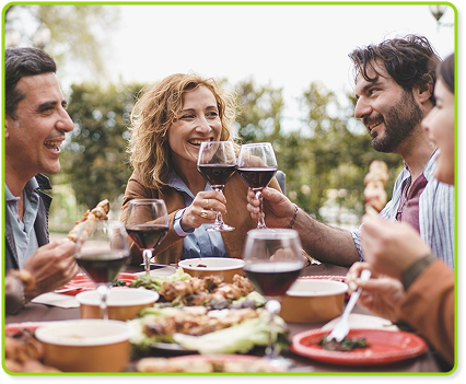Outdoor garden celebration with friends toasting with wine, joy, and delicious food.