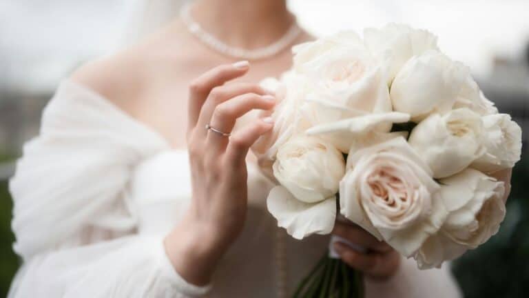 Bride holding a beautiful white rose bouquet at her wedding.