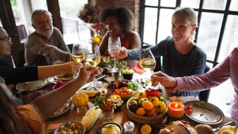 Diverse group of friends enjoying a meal, sharing laughs and conversation.