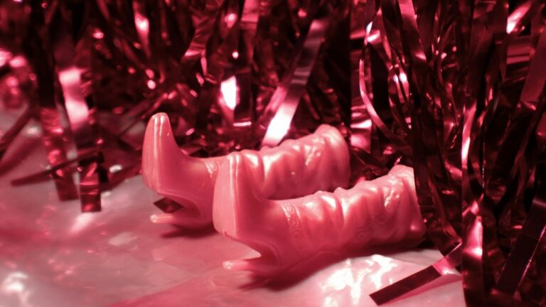 Vintage 1920s party decor featuring pink lips and shiny streamers for a murder mystery dinner.