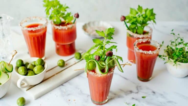 Refreshing Bloody Mary drinks garnished with herbs and olives for brunch.