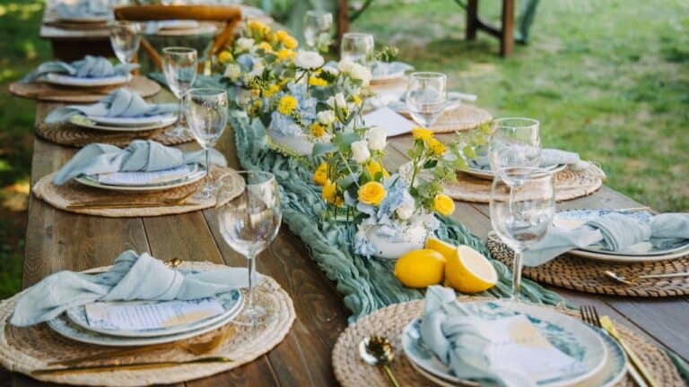 Outdoor dinner table setting with floral arrangement and lemon decorations.