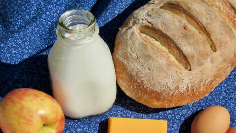Fresh baked bread with a glass of milk, apple, and egg for breakfast.