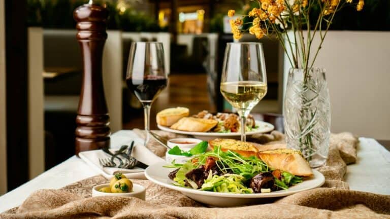 Romantic dinner setting with wine, salad, and bread for two.