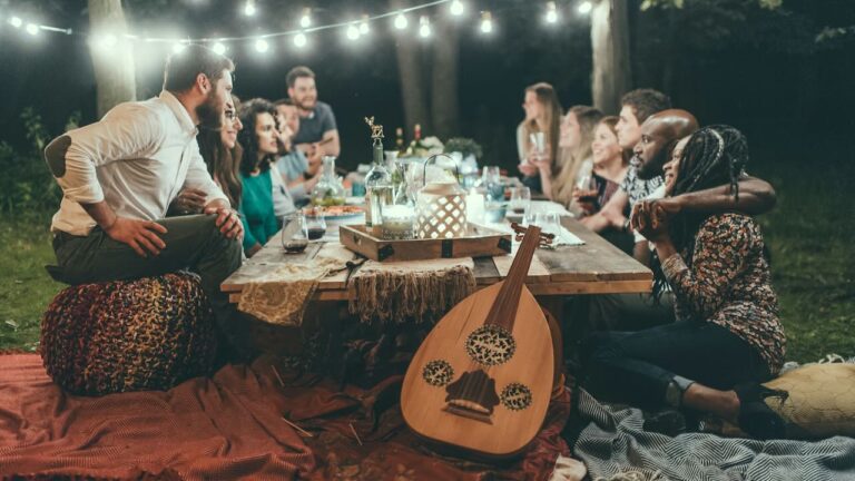 Outdoor dinner party with friends under string lights.