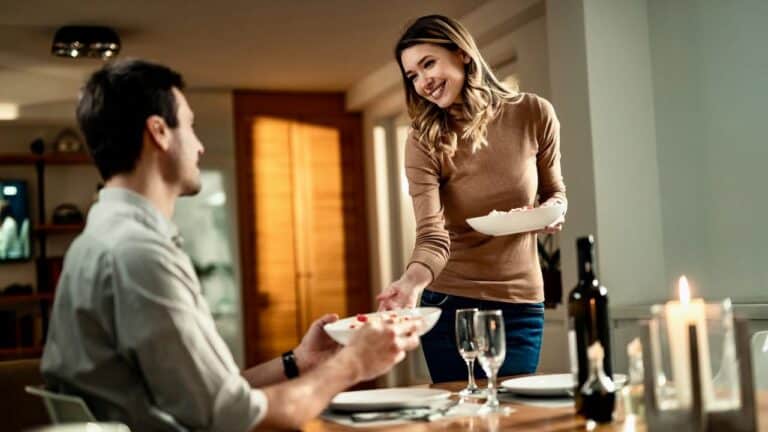 Intimate couple sharing a meal during a cozy dinner date at home.