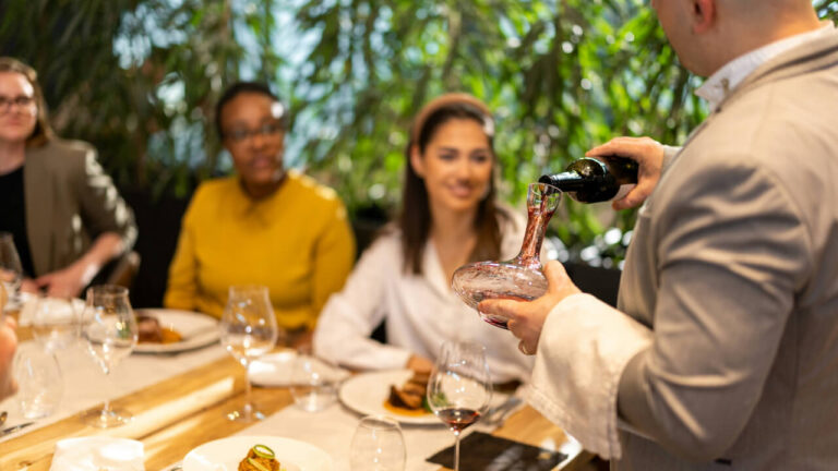 Elegant table setting with sunflowers, candles, and glassware for hosting a party.