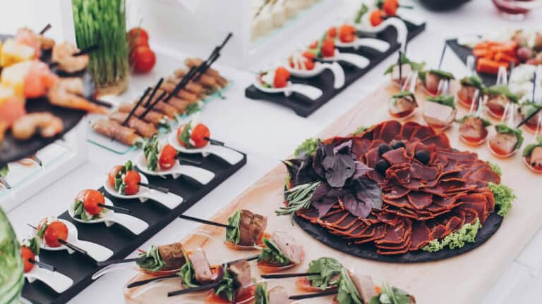 Elegant grazing table with assorted meats, cheeses, and fresh vegetables.