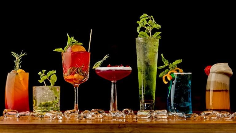 Colorful non-alcoholic cocktails with fresh herbs and fruits on a bar.