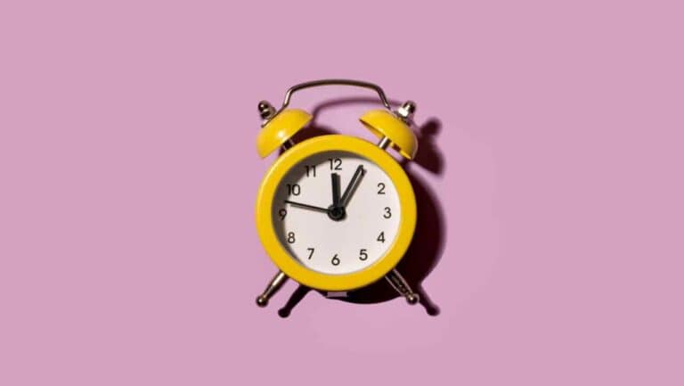 Alarm clock showing 9:00 AM on a pink background.