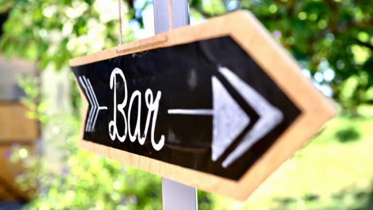 Bar sign pointing to the right for party drinks and socializing.