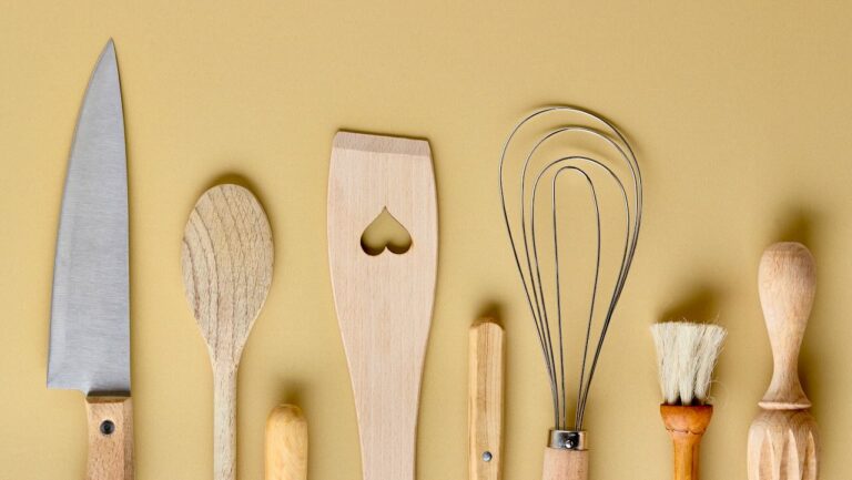 Kitchen utensils including a knife, spoon, spatula, whisk, and brush for efficient meal prep.