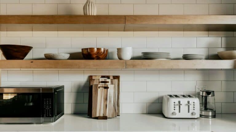 Modern kitchen shelf with bowls, plates, and kitchen appliances for organized space.