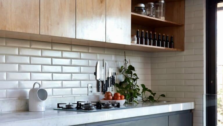 Modern kitchen with organized utensils, spices, and plants for a neat look.