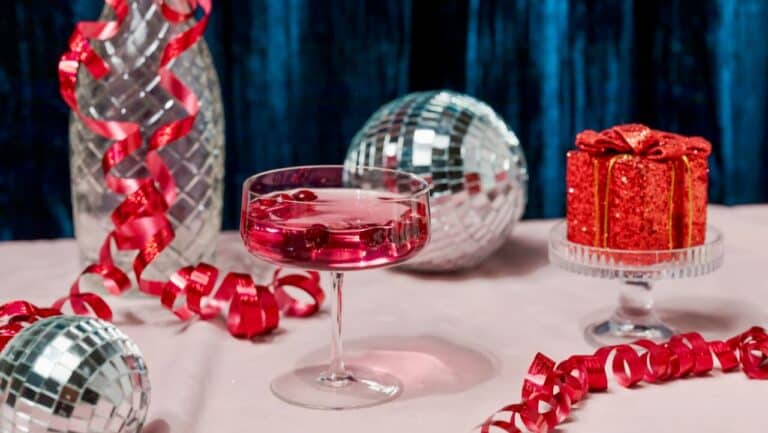 Elegant party setup with festive gifts, disco balls, and decorative ribbons for a bar-themed celebra.