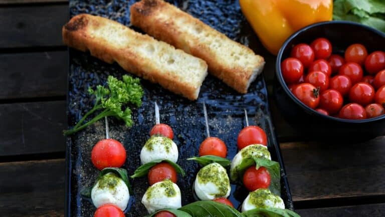 Delicious tomato and mozzarella skewers with fresh basil, perfect for outdoor summer dinner parties.