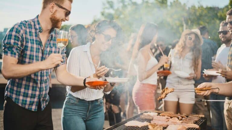 Outdoor summer dinner party with friends and grilled food.