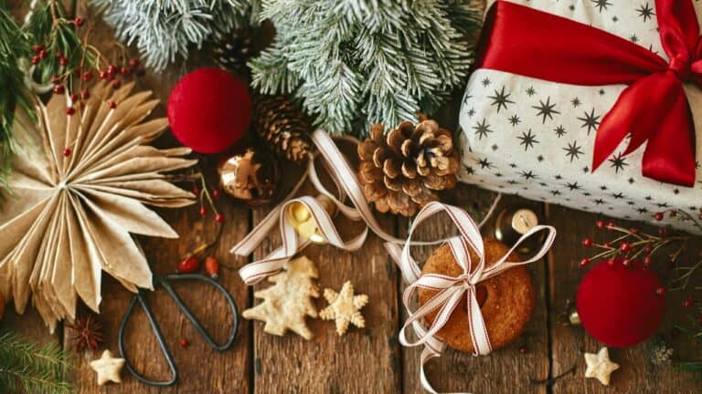 Festive holiday decorations with wrapped gifts, pinecones, and Christmas ornaments on a wooden surfa.