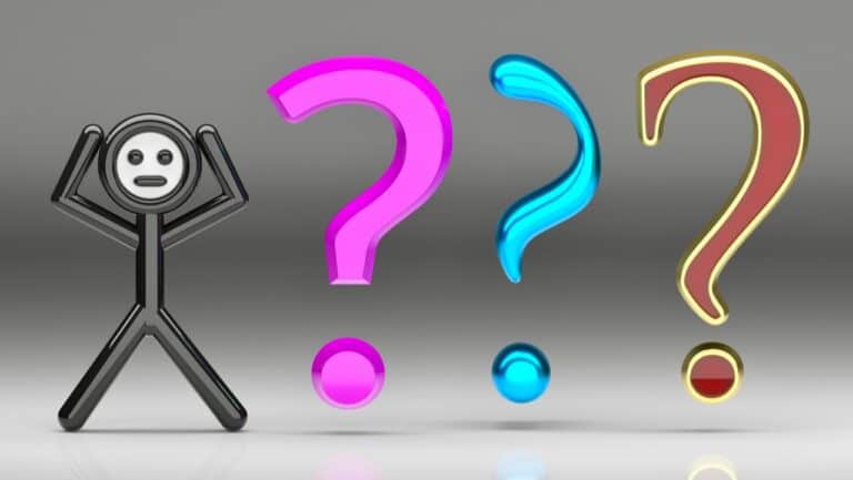 A person holding their head in confusion with three large colorful question marks in front of them.