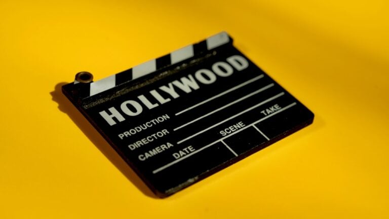 Hollywood film clapperboard on yellow background, symbolizing movie production and entertainment.