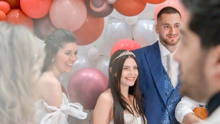 Happy guests at a bridal shower with colorful balloons in the background.