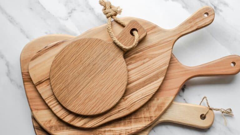 Elegant wooden cutting boards stacked on a marble surface, ideal for gourmet food preparation and pr.