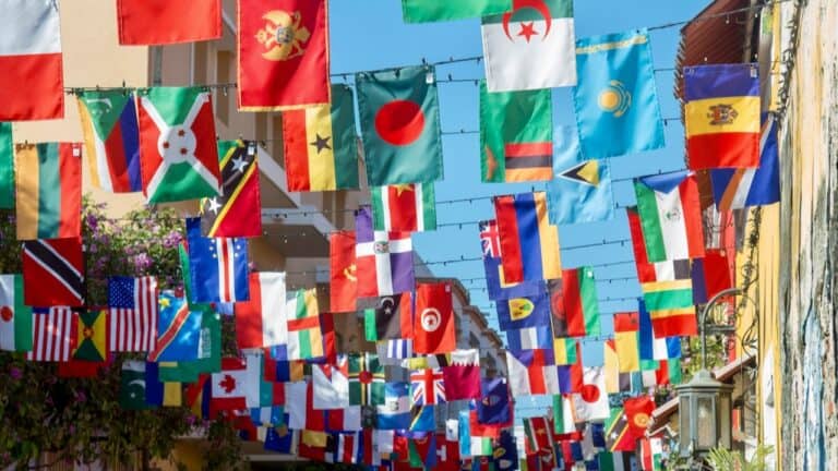 Colorful international flags hanging above a street scene, celebrating global diversity and cultural.