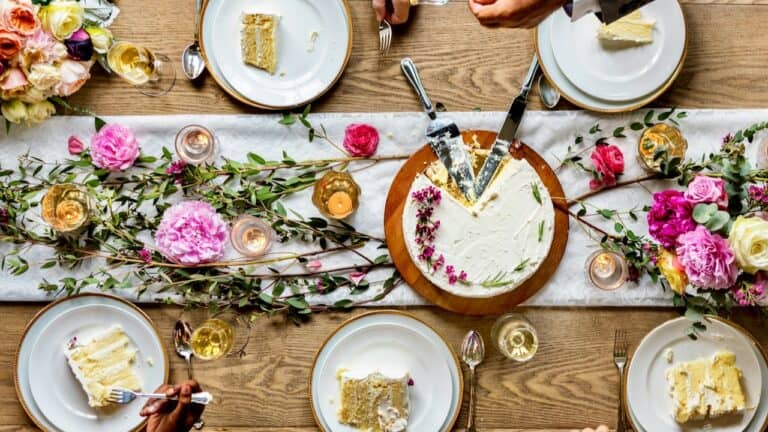 Elegant engagement party table with cake, flowers, and candles.