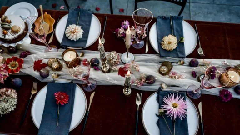 Elegant holiday-themed dinner table setup with festive decorations and floral accents.
