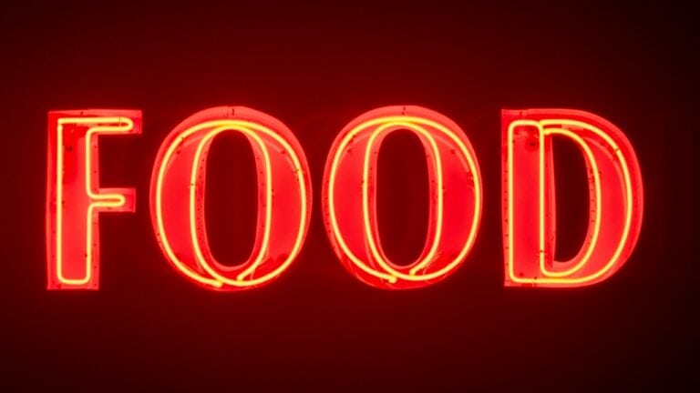 Freshly lit neon "FOOD" sign in vibrant red, perfect for food-related branding and restaurant decor.