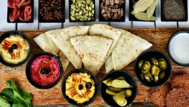 Authentic Indian naan bread with assorted chutneys and spices on a wooden platter.