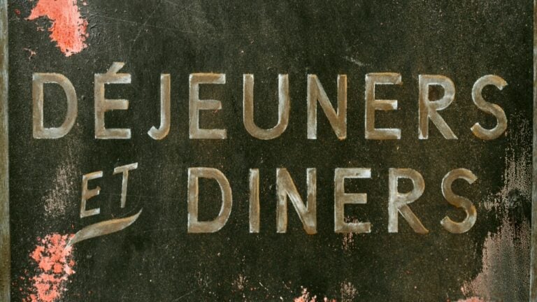 Elegant breakfast and dinner menu sign with French text "Déjeuners et Dîners" on a rustic chalkboard.