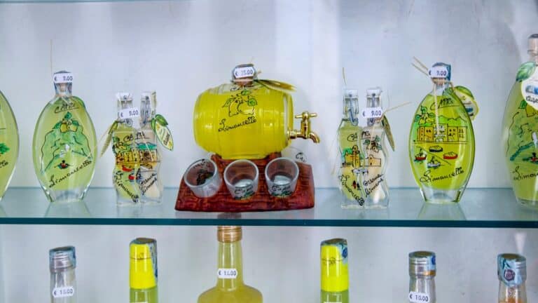 A colorful display of glass bottles and jars with a central yellow beverage dispenser on a glass she.
