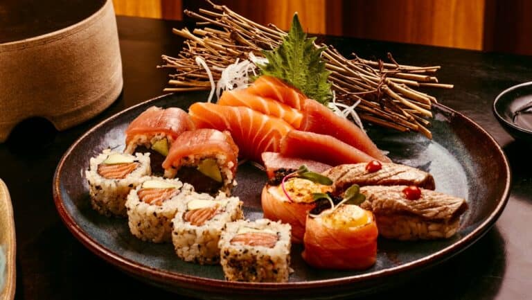 Fresh sushi platter with salmon, tuna, and assorted rolls, served with garnishes and wasabi.