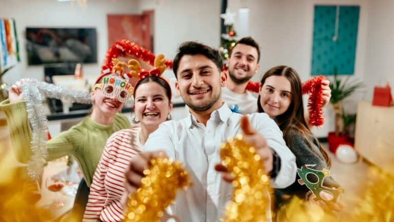 A festive group of friends celebrating Christmas with party hats and decorations.