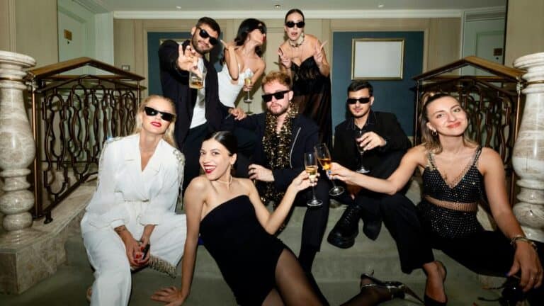 Elegant group of friends celebrating at a themed dinner party, dressed stylishly with drinks in hand.