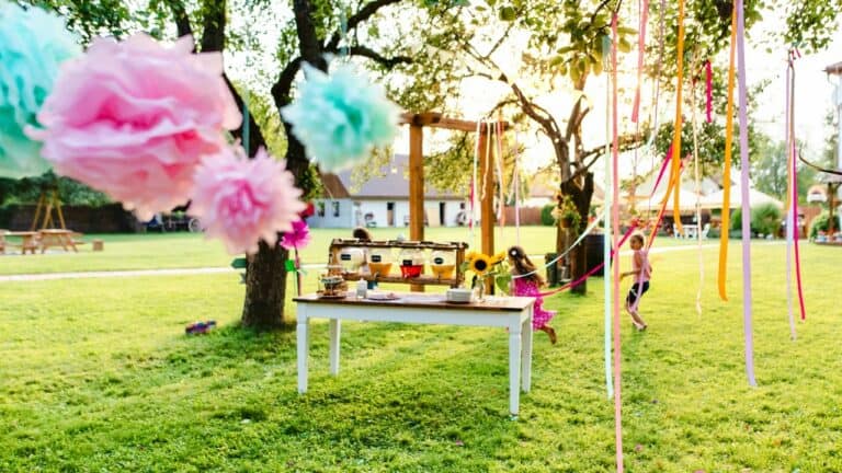 Outdoor graduation party setup with colorful decorations and a dessert table.