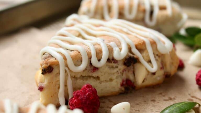 Delicious raspberry-filled pastry drizzled with white icing on a rustic surface.