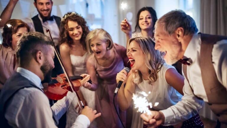 Guests singing and celebrating at an engagement party with music and sparklers.