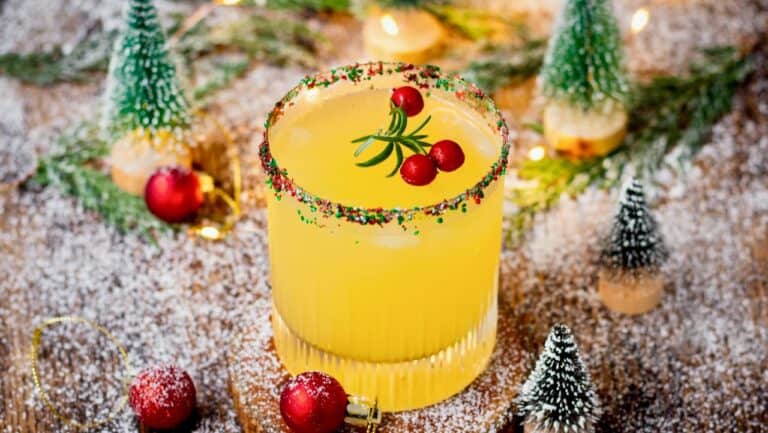 Festive non-alcoholic yellow drink with red berries and sprinkles.